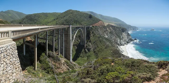 Bixby Bridge arching over a cove on the Big Sur coast with waves breaking below