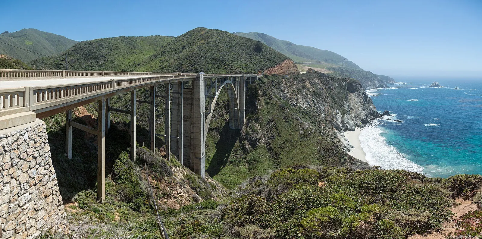 Bixby Bridge arching over a cove on the Big Sur coast with waves breaking below