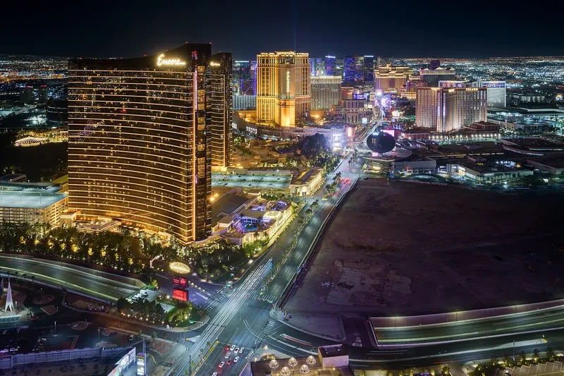 The Las Vegas Strip at night with illuminated resorts and the Bellagio fountain lake in the foreground