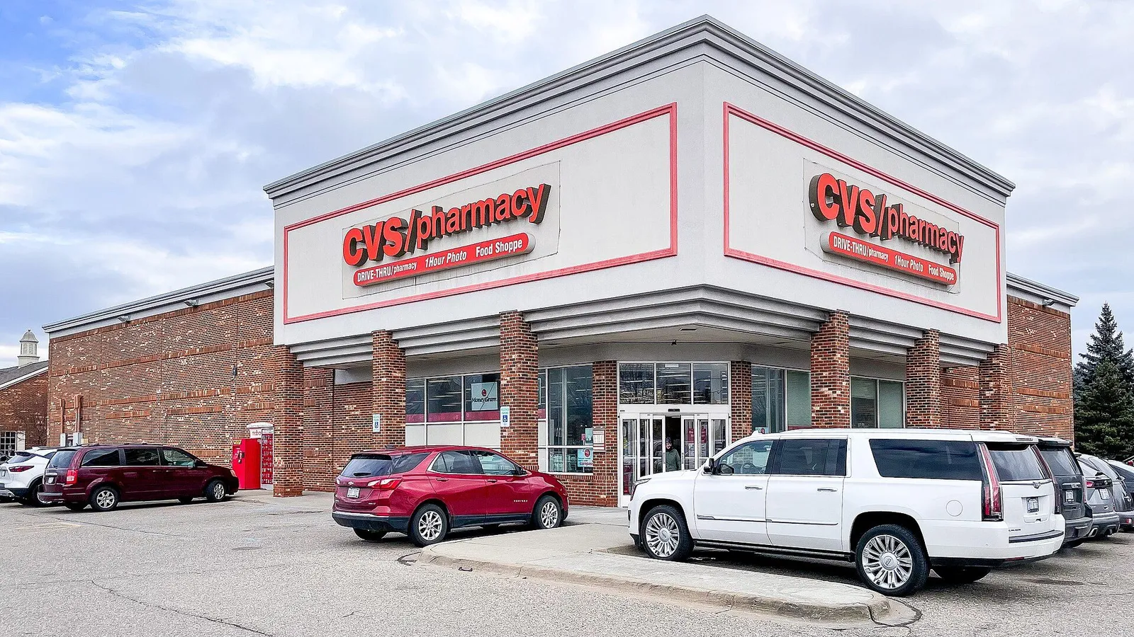 Pharmacy storefront with a green cross sign in the United States