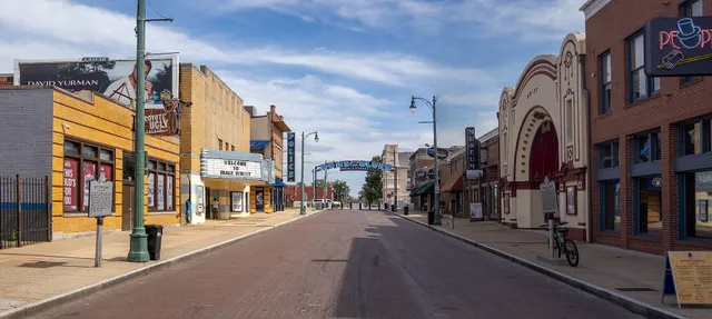 Neon signs glowing over a honky-tonk street at night in the American South