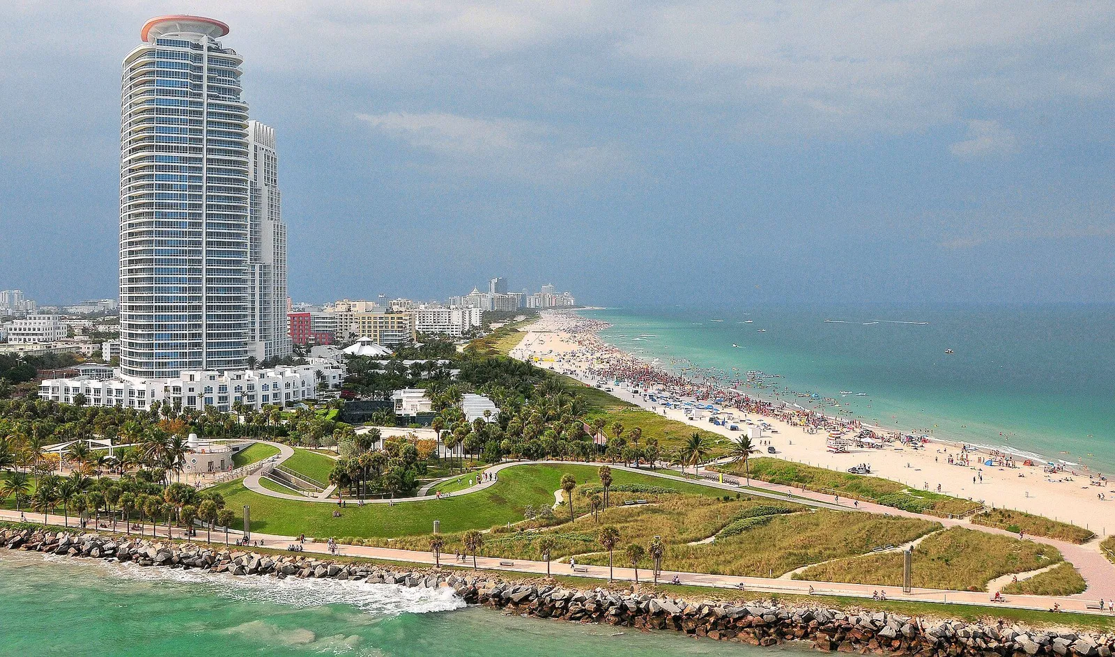 South Beach shoreline with pale sand, turquoise ocean, and palm trees in the foreground