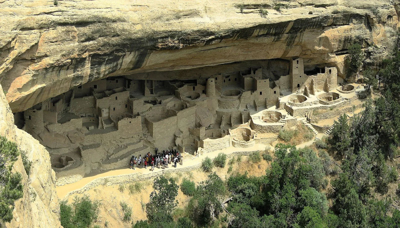Ancient stone cliff dwellings tucked under a sandstone canyon overhang at Mesa Verde