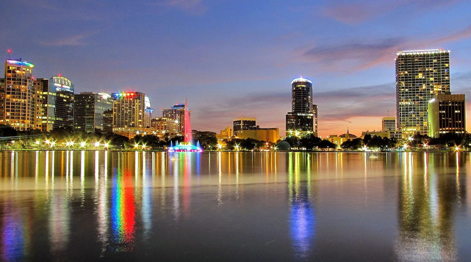Theme park attractions and lake scenery around Orlando with the city skyline beyond